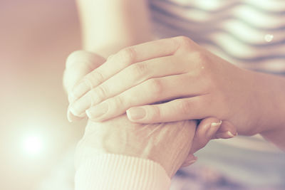 A woman is holding an elderly woman&apos;s hand
