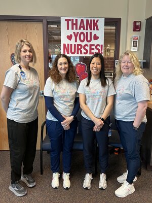 Pictured is four cardiac rehabilitation staff members. They are standing shoulder to shoulder while smiling in an office.