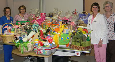 Four Nurses (females) putting together easter baskets to raise funds for a Digital Mammography Unit