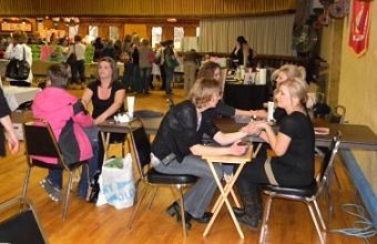 Women sitting down at tables during the 7th annual girlfriends getaway. There is six females